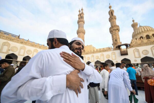 Muslim worshippers greet each other after the morning prayers for Eid al-Adha at the historic Azhar mosque in the centre of Cairo, Egypt. - Sputnik Africa