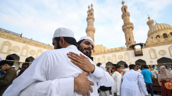 Верующие мусульмане приветствуют друг друга после утренней молитвы по случаю праздника Курбан-Байрам в исторической мечети Азхар в центре Каира, Египет - Sputnik Africa