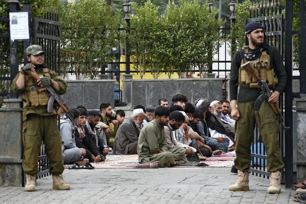 Taliban security personnel stand guard as men pray outside the Shah-e Doh Shamshira mosque ahead of the Muslim festival Eid al-Adha in Kabul, Afghanistan. - Sputnik Africa