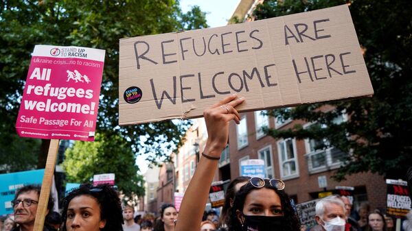 Protesters hold placards as they gather outside the Home Office in central London on June 13, 2022, to demonstrate against the UK government's intention to deport asylum-seekers to Rwanda. - Sputnik Africa