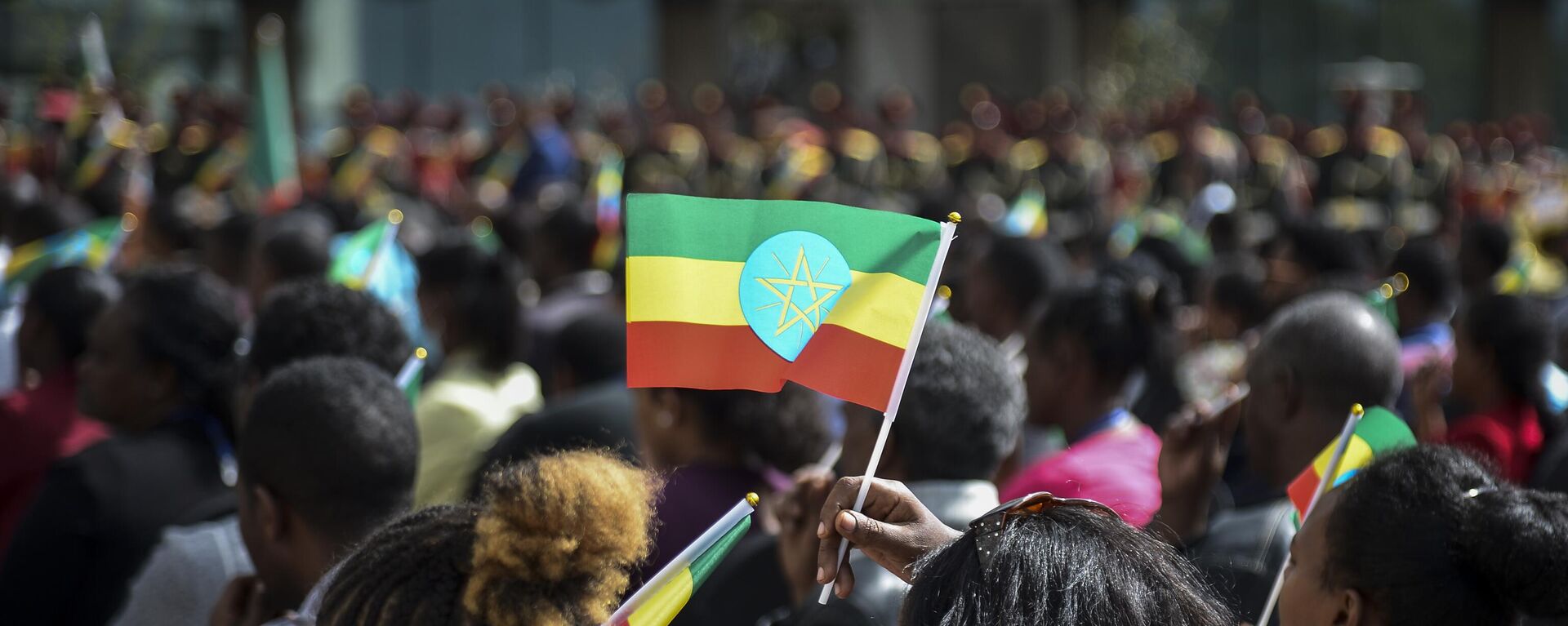 A member of the audience holds a national flag at a ceremony to remember those soldiers who died on the first day of the Tigray conflict, outside the city administration office in Addis Ababa, Ethiopia on Nov. 3, 2022.  - Sputnik Africa, 1920, 29.06.2023