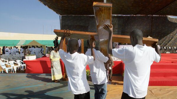 Worshippers erect a large croiss in the Demba Diop stadium in Dakar 02 December 2007, where Mgr Thйodore Adrien Sarr, recently created cardinal , celebrated his first mass as cardinal.  - Sputnik Africa