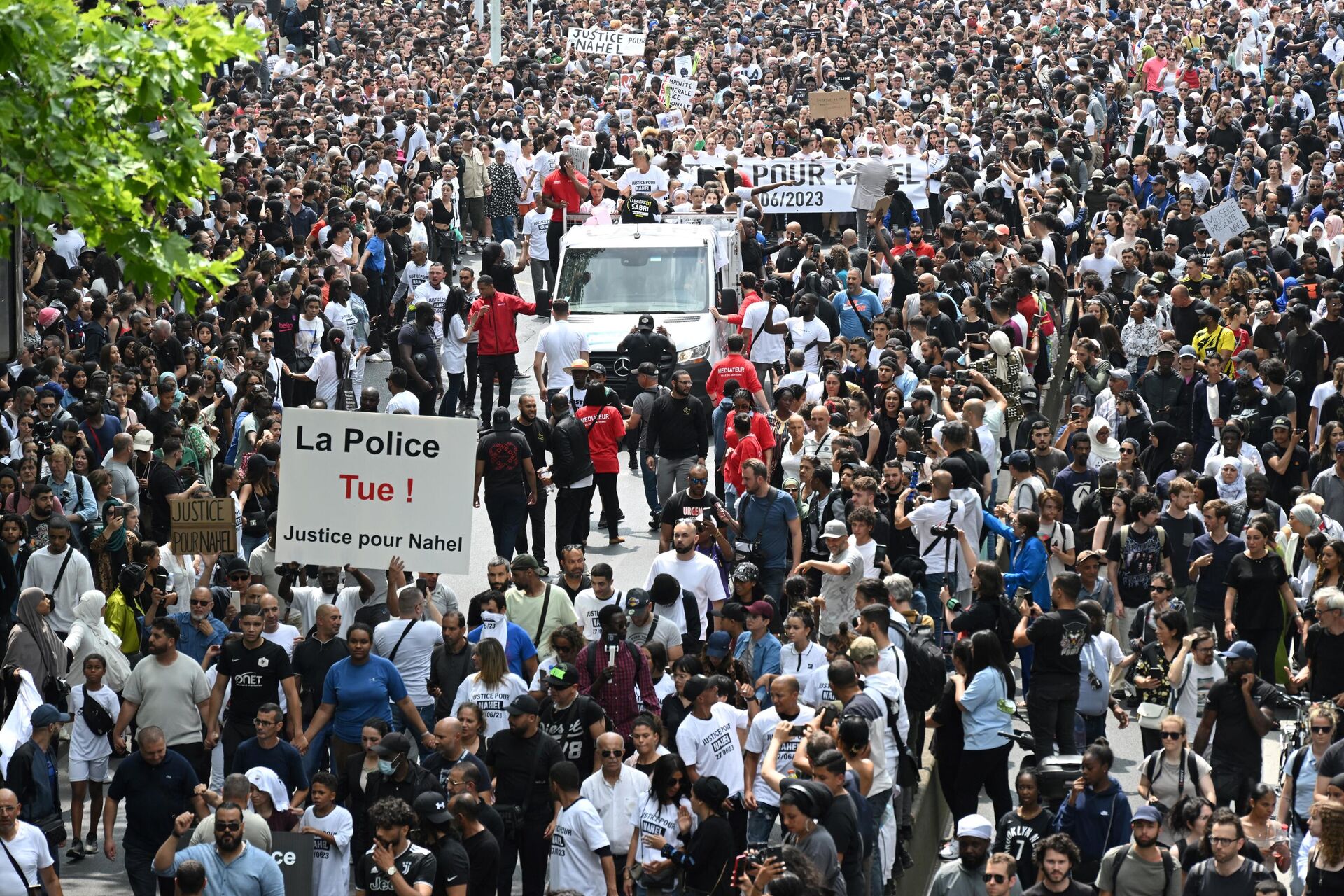 Mounia (C), the mother of Nahel, a teenage driver shot dead by a policeman, sits atop a truck as a protester holds a placard reading The police kills, justice for Nahel during a commemoration march for her son, in the Parisian suburb of Nanterre, on June 29, 2023.  - Sputnik Africa, 1920, 30.06.2023