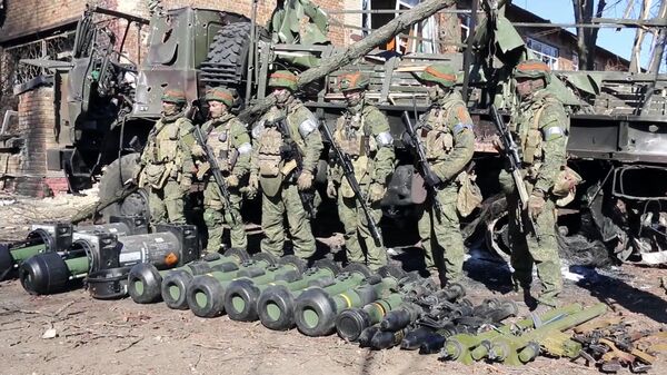 In this handout video grab released by the Russian Defence Ministry, Russian servicemen are pictured by military equipment captured by Russian troops during Russia's military operation in Ukraine, near the village of Huta-Mezhyhirska, in Ukraine - Sputnik Africa