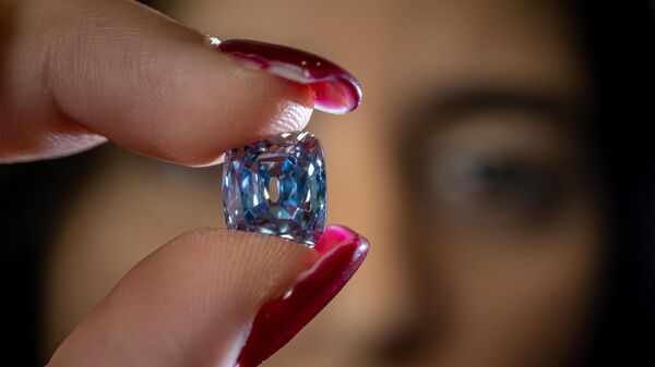 A model holds a De Beers cushion brilliant-cut fancy vivid blue 5.53 carats diamond that could fetch 15 million US dollars during a press preview by Sotheby's auction house ahead of sale in Geneva on November 3, 2022.  - Sputnik Africa