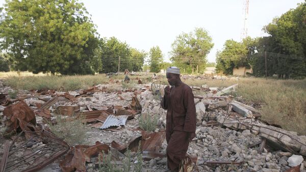 In this Friday Nov.12, 2010 file photo, an unidentified man stands on the remains of the destroyed Boko Haram mosque in Maiduguri, Nigeria. - Sputnik Africa