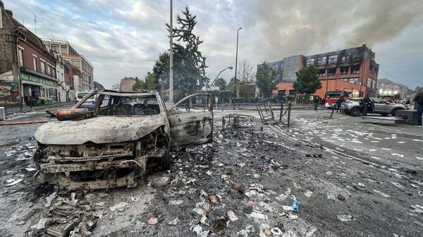 Сгоревший автомобиль и сгоревшее зданиние после протестов во французском городе Рубе - Sputnik Africa