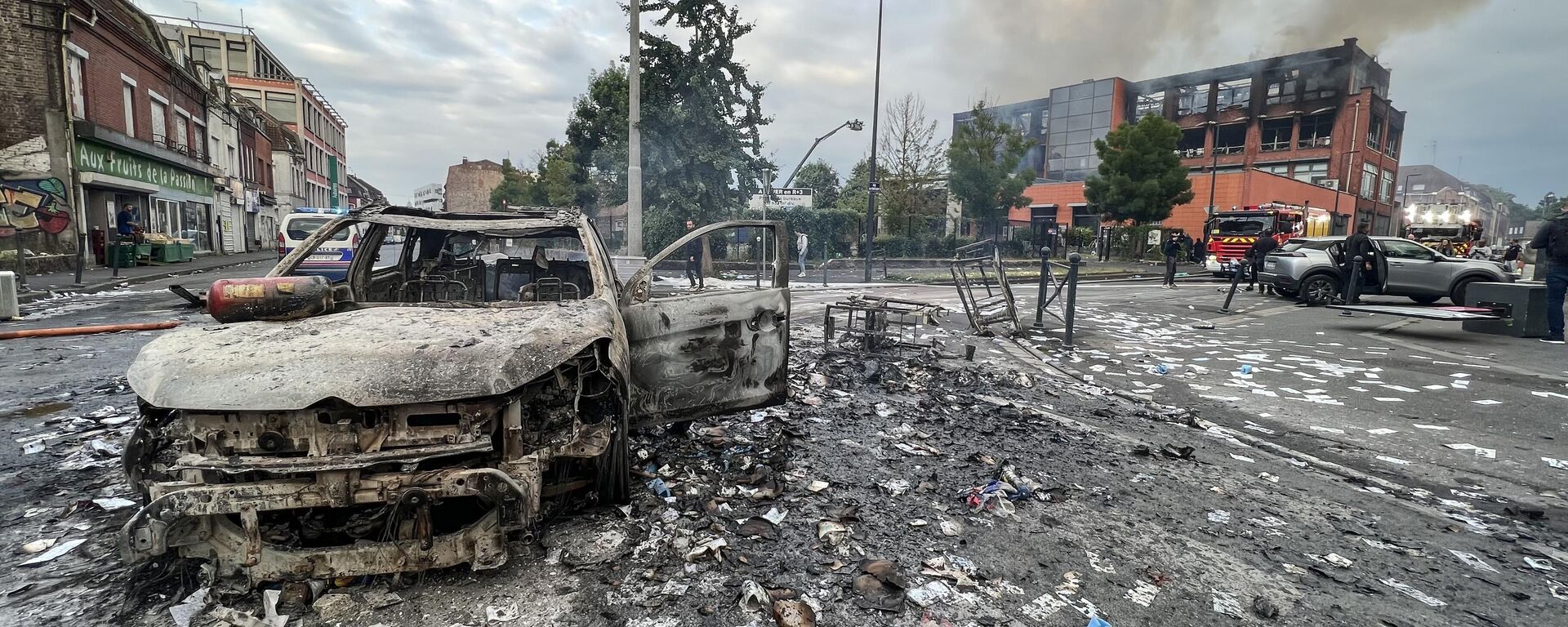 Сгоревший автомобиль и сгоревшее зданиние после протестов во французском городе Рубе - Sputnik Africa, 1920, 04.07.2023