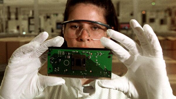An Intel employee hold up a Pentium III chip in one of the clean rooms where computer chips are manufactured at the Intel plant in Belen, Costa Rica, approximately 20 kilometers (12 miles) west of the capital of San Jose, Costa Rica, Friday, Aug. 11, 2000.  - Sputnik Africa