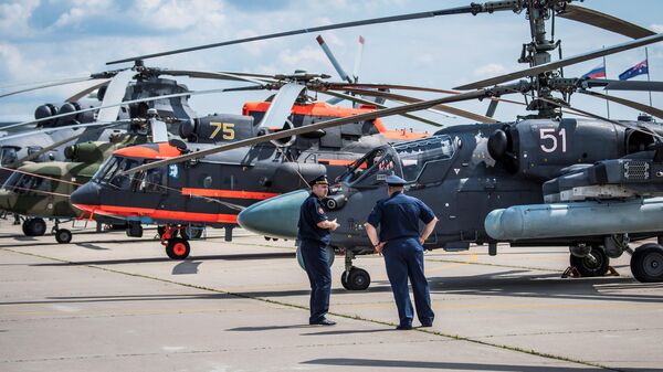 Russian pilots stand next to their military helicopters exhibited at the annual air show MAKS 2017 in Zhukovsky on July 18, 2017, some 40 km outside Moscow. (Photo by Mladen ANTONOV / AFP) - Sputnik Africa