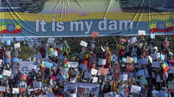 Ethiopians protest against international pressure on the government over the conflict in Tigray, below a banner referring to The Grand Ethiopian Renaissance Dam - Sputnik Africa