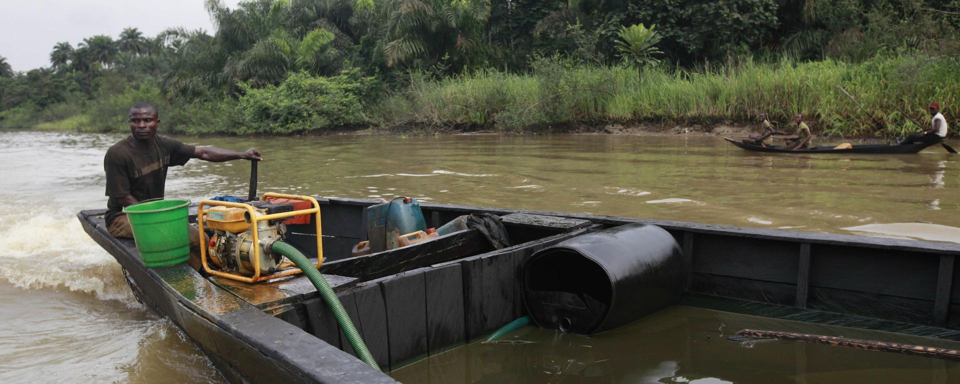 A suspected oil thief rides a wooden boat full of stolen crude oil on the creeks of Bayelsa, Nigeria - Sputnik Africa, 1920, 11.07.2023