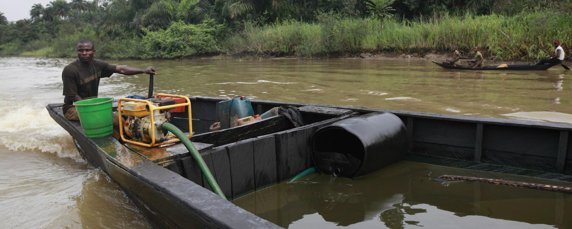 A suspected oil thief rides a wooden boat full of stolen crude oil on the creeks of Bayelsa, Nigeria - Sputnik Africa, 1920, 11.07.2023