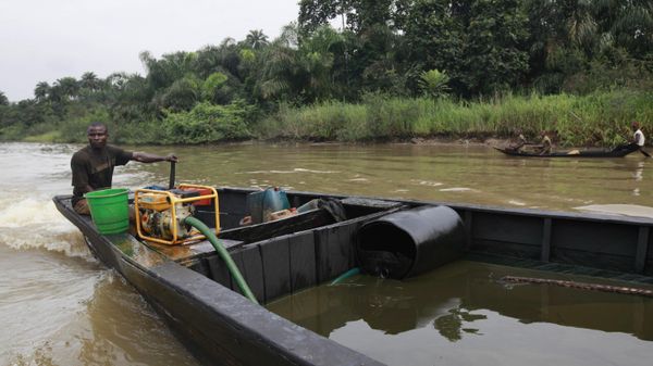 A suspected oil thief rides a wooden boat full of stolen crude oil on the creeks of Bayelsa, Nigeria - Sputnik Africa