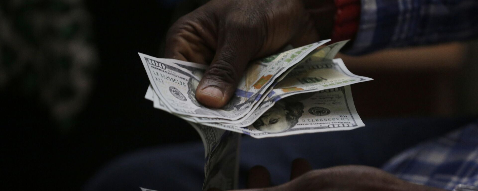 In this photo taken on Monday, June 20, 2016, a trader counts US dollars inside a shop in Lagos, Nigeria.  - Sputnik Africa, 1920, 13.07.2023