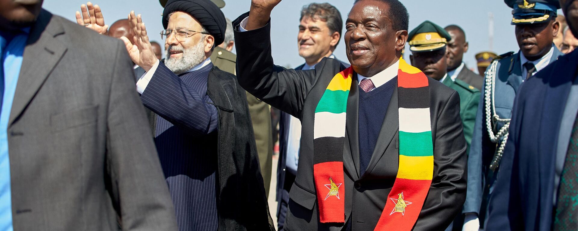 Zimbabwe President Emmerson Mnangagwa (R) waves next to Iranian President Ebrahim Raisi (L) who arrived on a state visit at the Robert Gabriel Mugabe International Airport in Harare on July 13, 2023 - Sputnik Africa, 1920, 13.07.2023