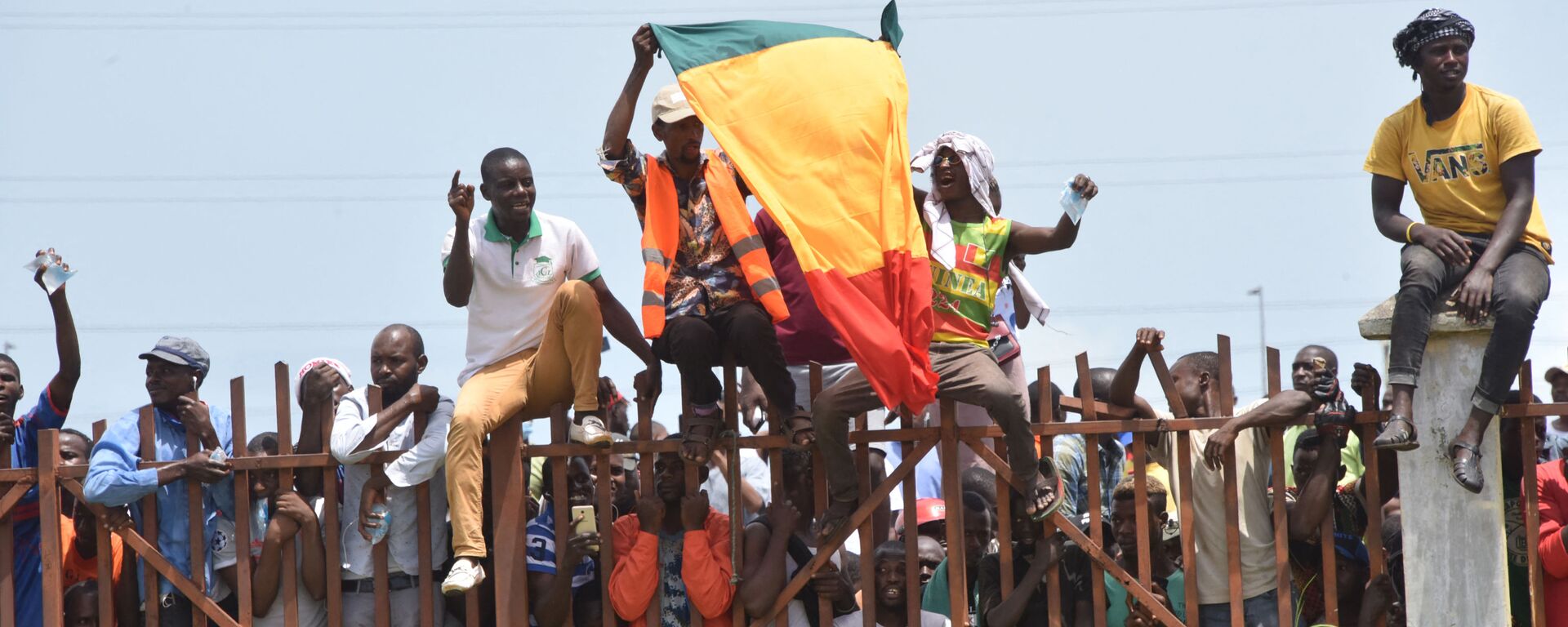 People hold up the Guinea national flag during celebrations as the Guinean Special Forces arrive at the Palace of the People in Conakry on September 6, 2021, ahead of a meeting with the Ministers of the ex-President of Guinea Alpha Conde.  - Sputnik Africa, 1920, 19.07.2023