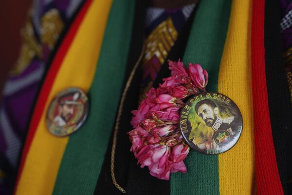 A Rastafari member wears two buttons depicting Haile Selassie I, the late Ethiopian emperor, while waiting for service to start at the Ras Freeman Foundation for the Unification of Rastafari tabernacle on Sunday, May 14, 2023, in Liberta, Antigua. Most of the Rastafari sects worship Selassie. This is rooted in Jamaican Black nationalist leader Marcus Garvey’s 1920s prediction that a “Black king shall be crowned” in Africa, ushering in a “day of deliverance.” When an Ethiopian prince named Ras Tafari, who took the name Haile Selassie I, became emperor in 1930, the descendants of slaves in Jamaica took it as proof that Garvey’s prophecy was being fulfilled. - Sputnik Africa