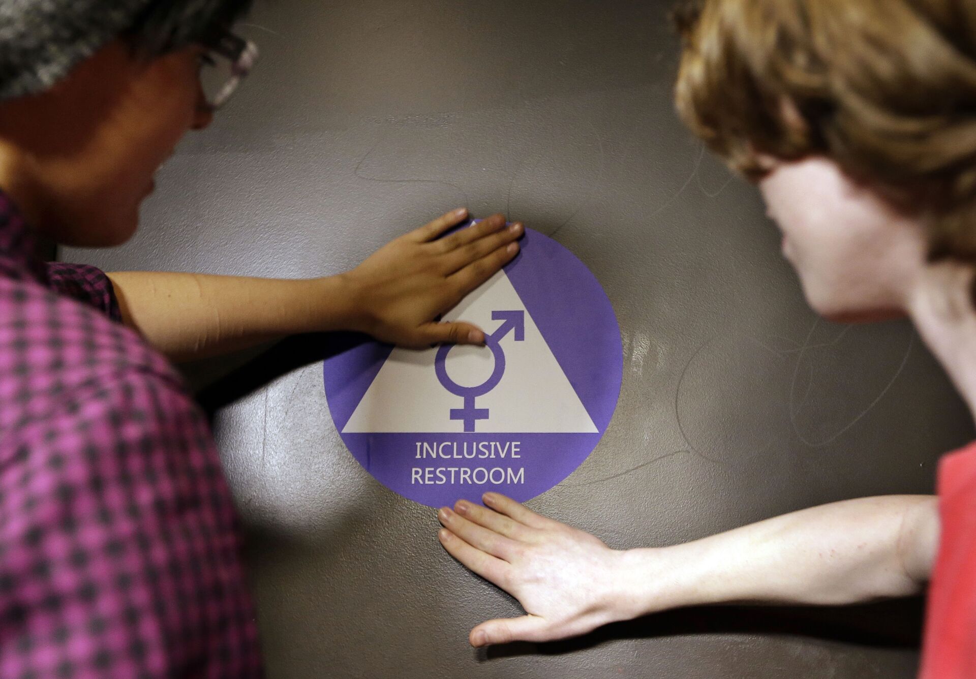 Destin Cramer, left, and Noah Rice place a new sticker on the door at the ceremonial opening of a gender neutral bathroom at Nathan Hale high school Tuesday, May 17, 2016, in Seattle - Sputnik Africa, 1920, 28.07.2023