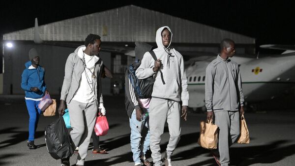 Migrants walk on the tarmac after being repatriated from from Dakla, Morocco at Yoff military airport in Dakar on July 26, 2023, in the aftermath of the capsize of a migrants boat.  - Sputnik Africa