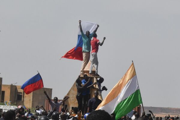 Protesters wave Nigerien and Russian flags as they rally in support of Niger&#x27;s military in Niamey on July 30, 2023.  - Sputnik Africa