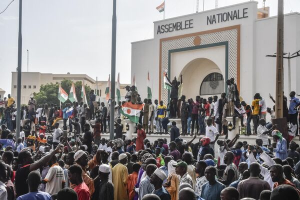 Supporters wave Nigerien flags as they rally in support of Niger&#x27;s military in front of the National Assembly in Niamey on July 30, 2023. - Sputnik Africa