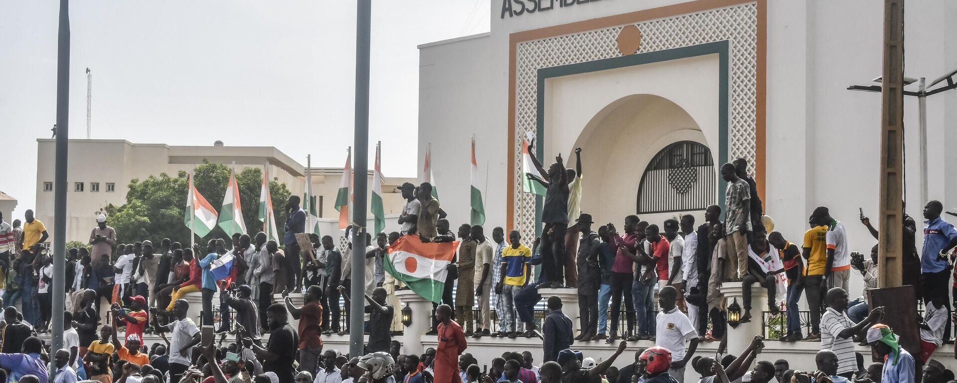 Supporters wave Nigerien's flags as they rally in support of Niger's junta in front of the National Assembly in Niamey on July 30, 2023.  - Sputnik Africa, 1920, 03.08.2023