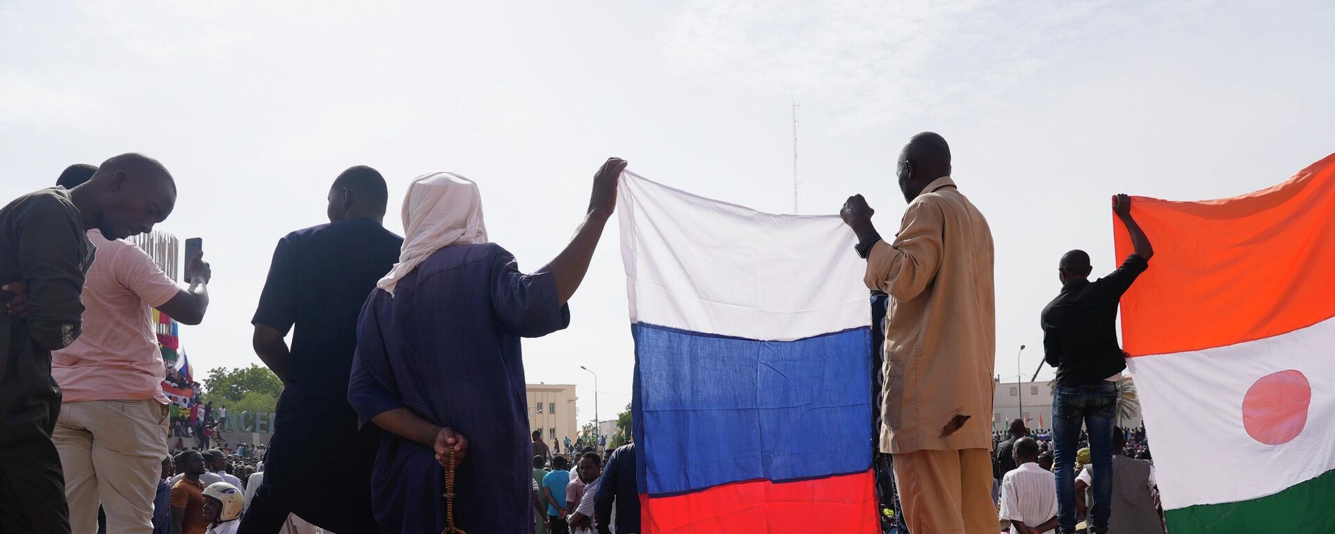 Нигерийцы с российским флагом в руках участвуют в марше, организованном сторонниками лидера государственного переворота генерала Дж. Абдурахман Кьянти в Ниамее - Sputnik Africa, 1920, 25.04.2024