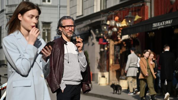 Two passers-by smoke on Zabelin Street in Moscowb Russia, April 23, 2022. - Sputnik Africa