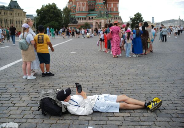 A foreign tourist lies back and relaxes on Red Square in Moscow. - Sputnik Africa