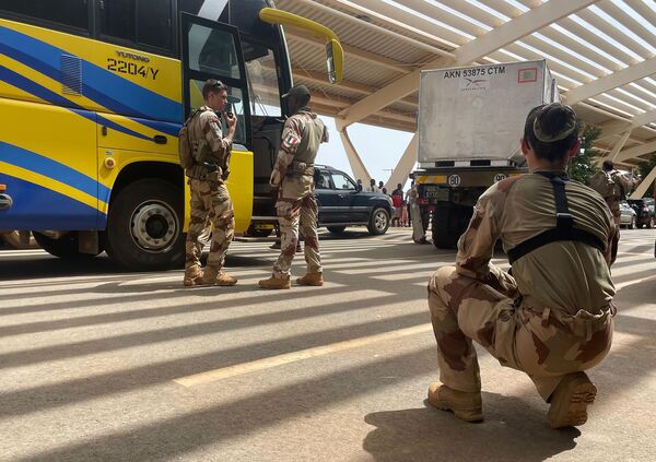 French soldiers assist mostly French nationals in a bus waiting to be airlifted back to France on a French military aircraft, at the international Airport in Niamey, Niger, Tuesday, Aug. 1, 2023. The French Foreign Ministry in Paris cited recent violence that targeted the French Embassy as one of the reasons for the evacuation. (AP Photo/Sam Mednick) - Sputnik Africa