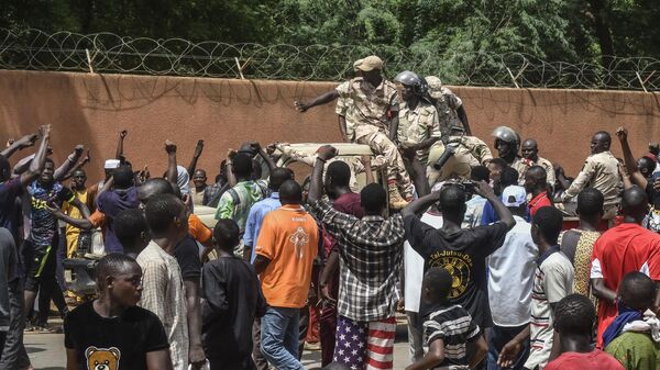 Protesters cheer Nigerien troops as they gather in front of the French Embassy in Niamey - Sputnik Africa