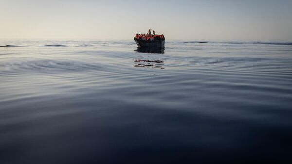 Migrants with life jackets provided by volunteers of the Ocean Viking, a migrant search and rescue ship run by NGOs SOS Mediterranee and the International Federation of Red Cross (IFCR), still sail in a wooden boat as they are being rescued, Aug. 27, 2022, in the Mediterranean sea - Sputnik Africa