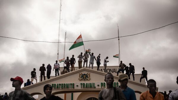 Protesters hold a Niger flag during a demonstration on independence day in Niamey on August 3, 2023. Hundreds of people backing the coup in Niger gathered on August 3, 2023 for a mass rally in the capital Niamey with some brandishing giant Russian flags. - Sputnik Africa
