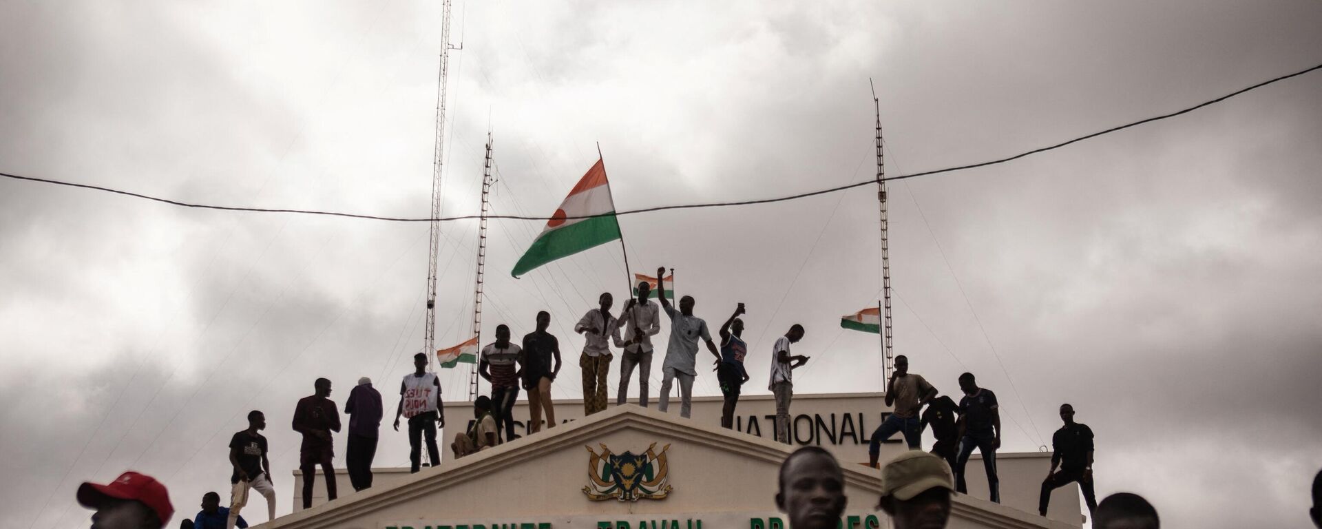 Protesters hold a Niger flag during a demonstration on independence day in Niamey on August 3, 2023. Hundreds of people backing the coup in Niger gathered on August 3, 2023 for a mass rally in the capital Niamey with some brandishing giant Russian flags. - Sputnik Africa, 1920, 10.08.2023
