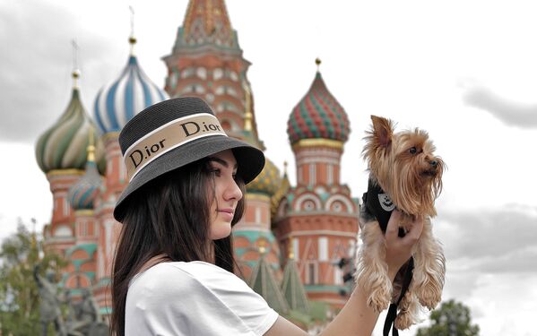 A young lady takes snapshots of her pooch on the Red Square. - Sputnik Africa