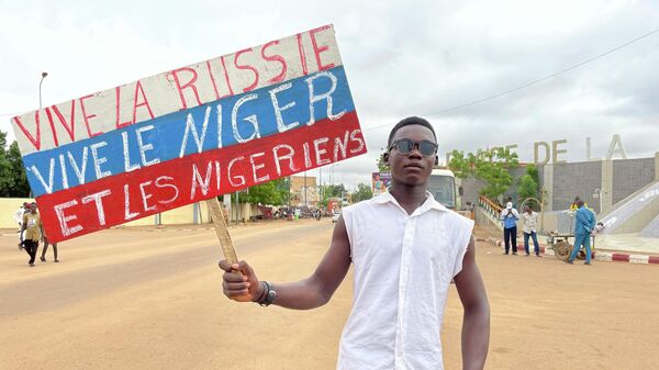 A Nigerien man holds a placard reading Long Live Russia, Long Live Niger and Nigeriens in the capital Niamey - Sputnik Africa