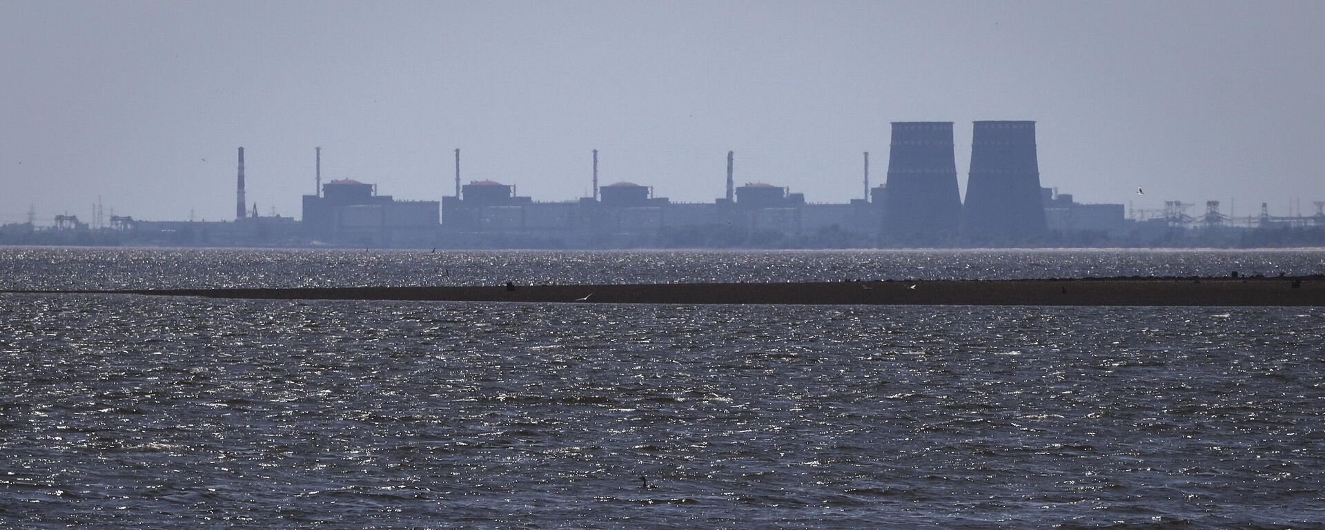 The Zaporozhye nuclear power plant is seen in the background of the shallow Kakhovka Reservoir after the dam collapse - Sputnik Africa, 1920, 09.08.2023