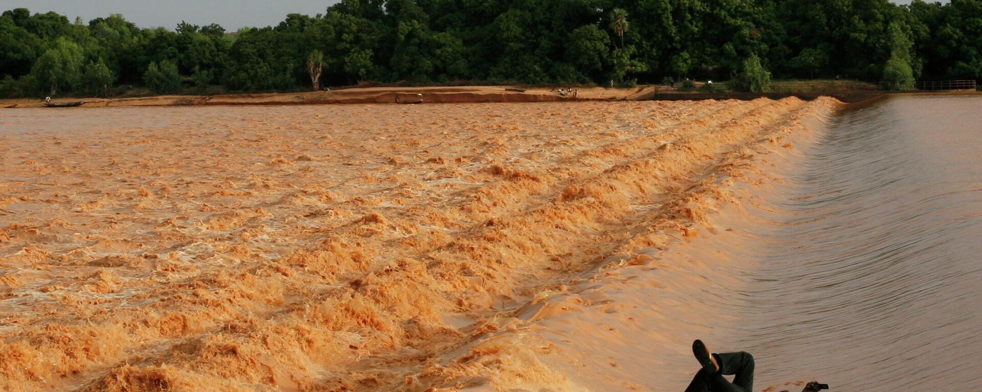 A fisherman takes a break on a concrete wall in the midst of the rain-swollen Niger river, late in the day in Niamey, Niger Friday, July 31, 2009.  - Sputnik Africa, 1920, 10.08.2023