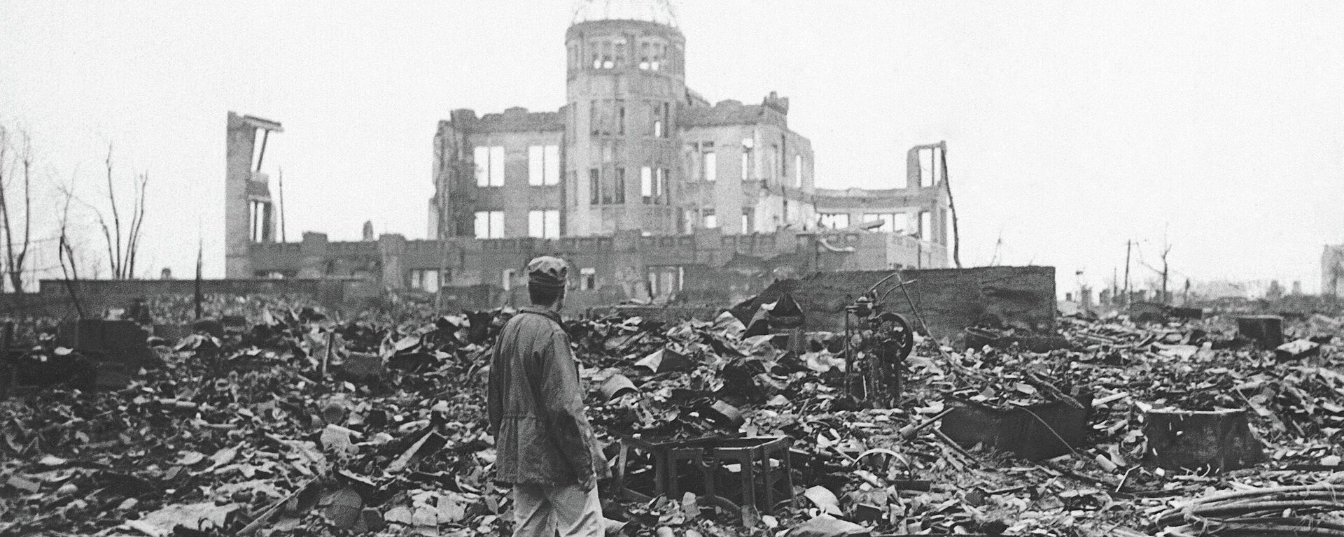 In this 1945 file photo, an Allied war correspondent stands in the ruins of Hiroshima, Japan, just weeks after the city was leveled by an atomic bomb. Many residents of Hiroshima welcome attention to their city from abroad, which IOC President Thomas Bach will bring when he visits on Friday, July 16. - Sputnik Africa, 1920, 12.01.2024