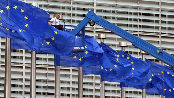 A worker on a lift adjusts the EU flags in front of EU headquarters in Brussels - Sputnik Africa