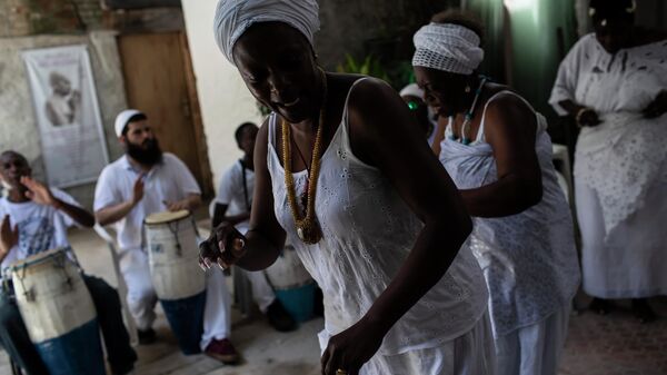 Members of Filhos de Gandhi, a Yoruba Afro-religious cultural group, dance during the first cultural and religious activity of the year in Rio de Janeiro, Brazil - Sputnik Africa