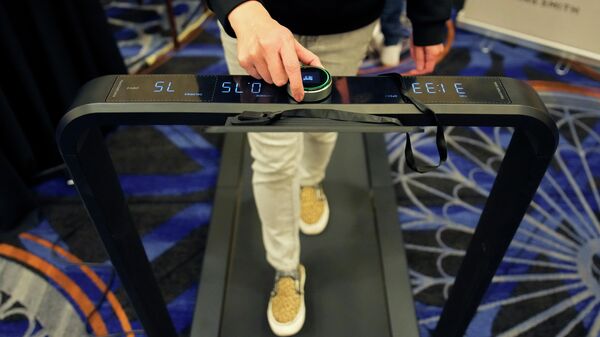 An exhibitor walks on the King Smith X21 WalkingPad Treadmill during the Pepcom Digital Experience before the start of the CES tech show, Wednesday, Jan. 4, 2023, in Las Vegas.  - Sputnik Africa