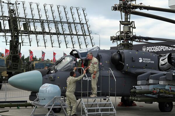Participants near a Ka-52 helicopter at the Army-2023 International Military-Technical Forum at the Patriot Congress and Exhibition Center. - Sputnik Africa