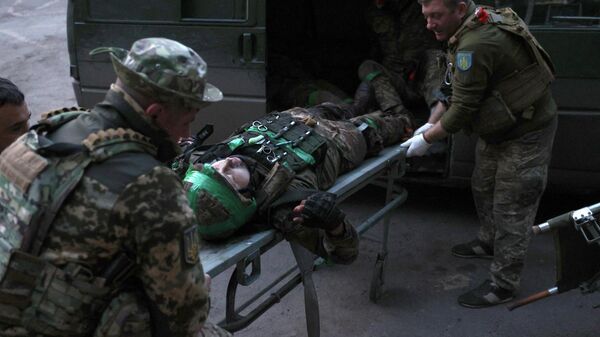 Ukrainian military medics carry a wounded Ukrainian serviceman delivered from a front line position to a stabilization point.  - Sputnik Africa