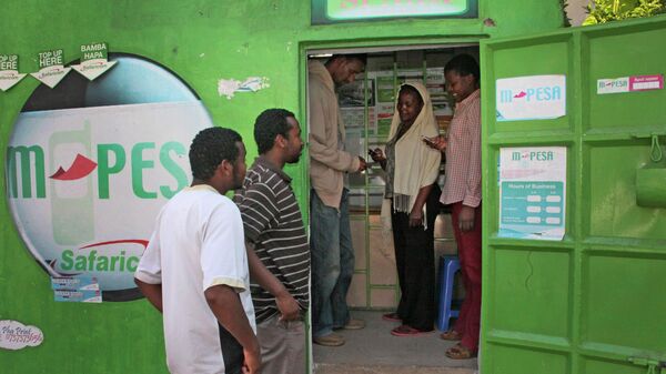 In this photo of Wednesday Aug. 24, 2011 customers make money transfers at an M-Pesa counter in Nairobi, Kenya, as others wait outside. - Sputnik Africa