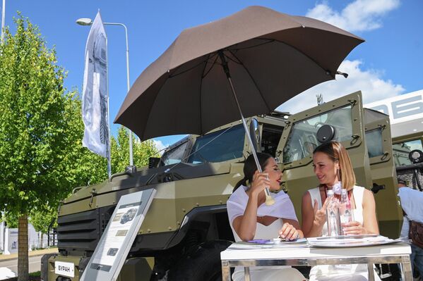 Two women sit next to the Buran-10 special armored vehicle at the exposition field in the Kubinka Patriot Park and Congress Center outside Moscow on August 16, 2023 during the International Military-Technical Forum Army-2023.  - Sputnik Africa