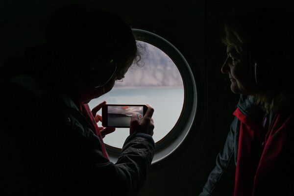 Journalists filming one of the islands of the Svalbard archipelago from a helicopter. - Sputnik Africa