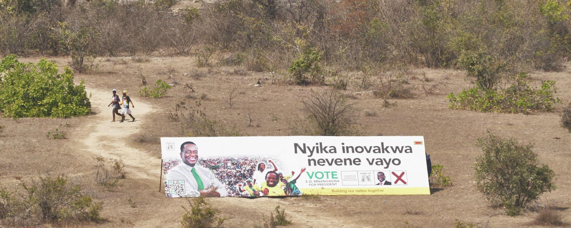 Supporters walk past a Zimbabwe African National Union – Patriotic Front (ZANU-PF) banner during an election campaign rally in Shurugwi on August 19, 2023. - Sputnik Africa, 1920, 21.08.2023