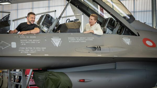 Volodymyr Zelensky et la Première ministre danoise Mette Frederiksen assis dans un avion de combat F-16 dans le hangar de la base aérienne de Skrydstrup à Vojens, dans le nord du Danemark, le 20 août 2023. - Sputnik Afrique